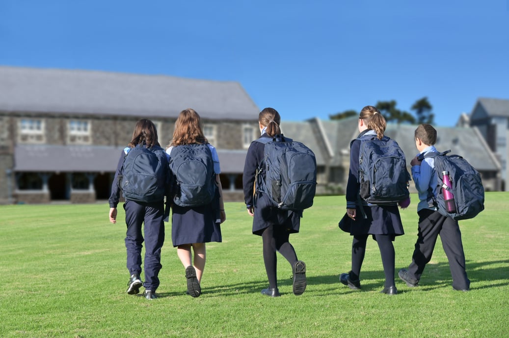 Students walking across a field dressed for school